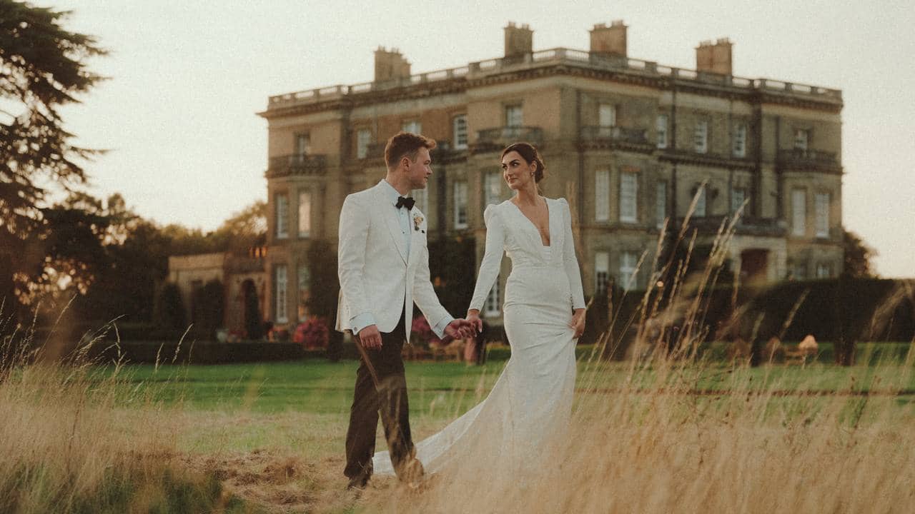 Wedding couple walking together outside a country house